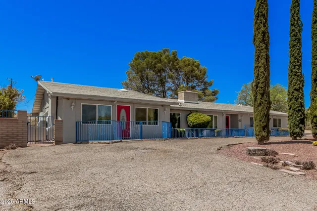 a view of a house with a yard and potted plants