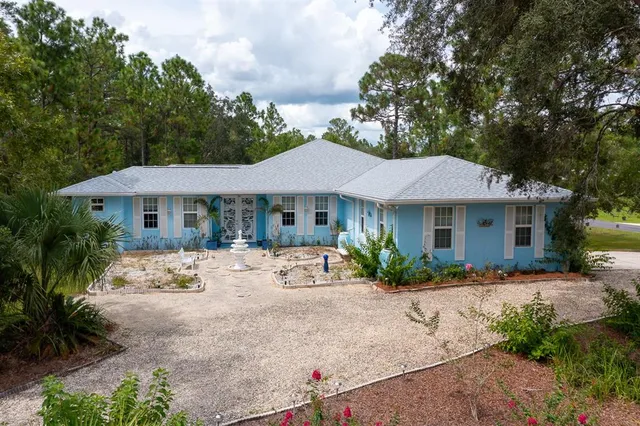 a view of a house with a yard and sitting area