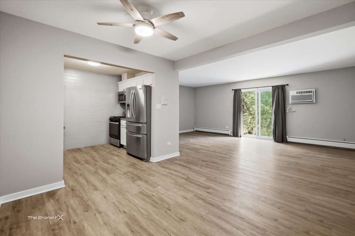144 East Bailey Road, Unit L Naperville, IL 60565 - Photo 8 of 21 an empty room with wooden floor a ceiling fan and windows