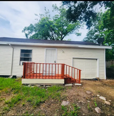 a view of a backyard with a large tree and wooden fence