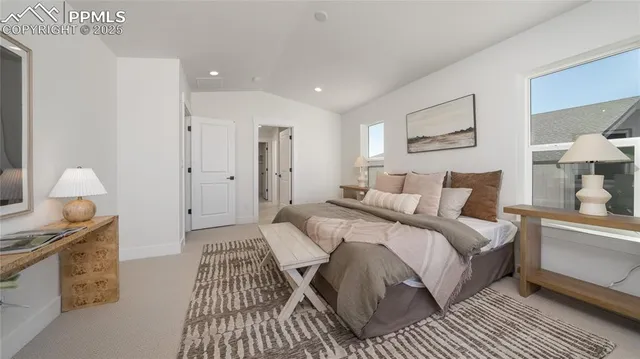 a spacious bedroom with a bed and a lamp on a dresser