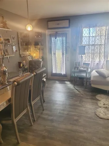 a living room with couches and a dining table with wooden floor