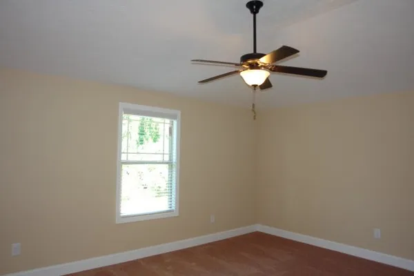 a room with a window and a chandelier fan