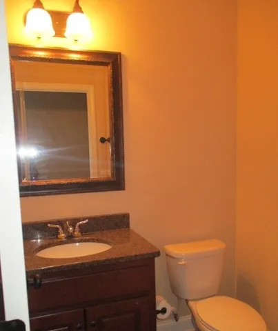 a bathroom with a toilet a sink and mirror