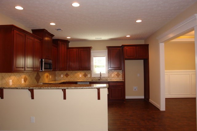 3521 Edgewood Road Columbus, GA 31907 - Photo 4 of 16 a kitchen with kitchen island granite countertop wooden cabinets and refrigerator