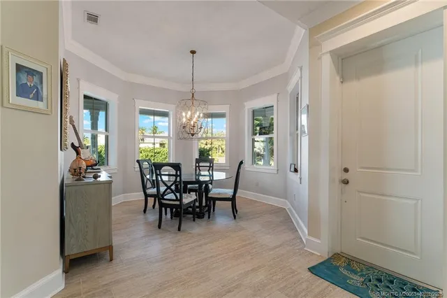 a large white kitchen with a large island oven a sink dishwasher and refrigerator with wooden floor
