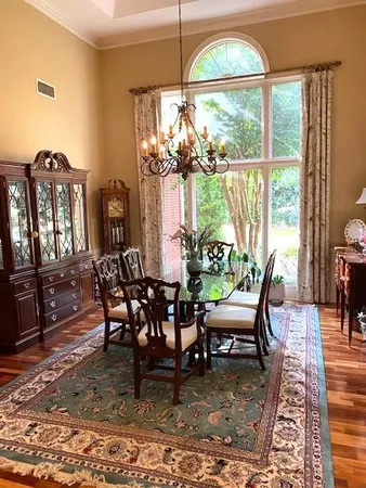 a dining room with furniture a chandelier and wooden floor