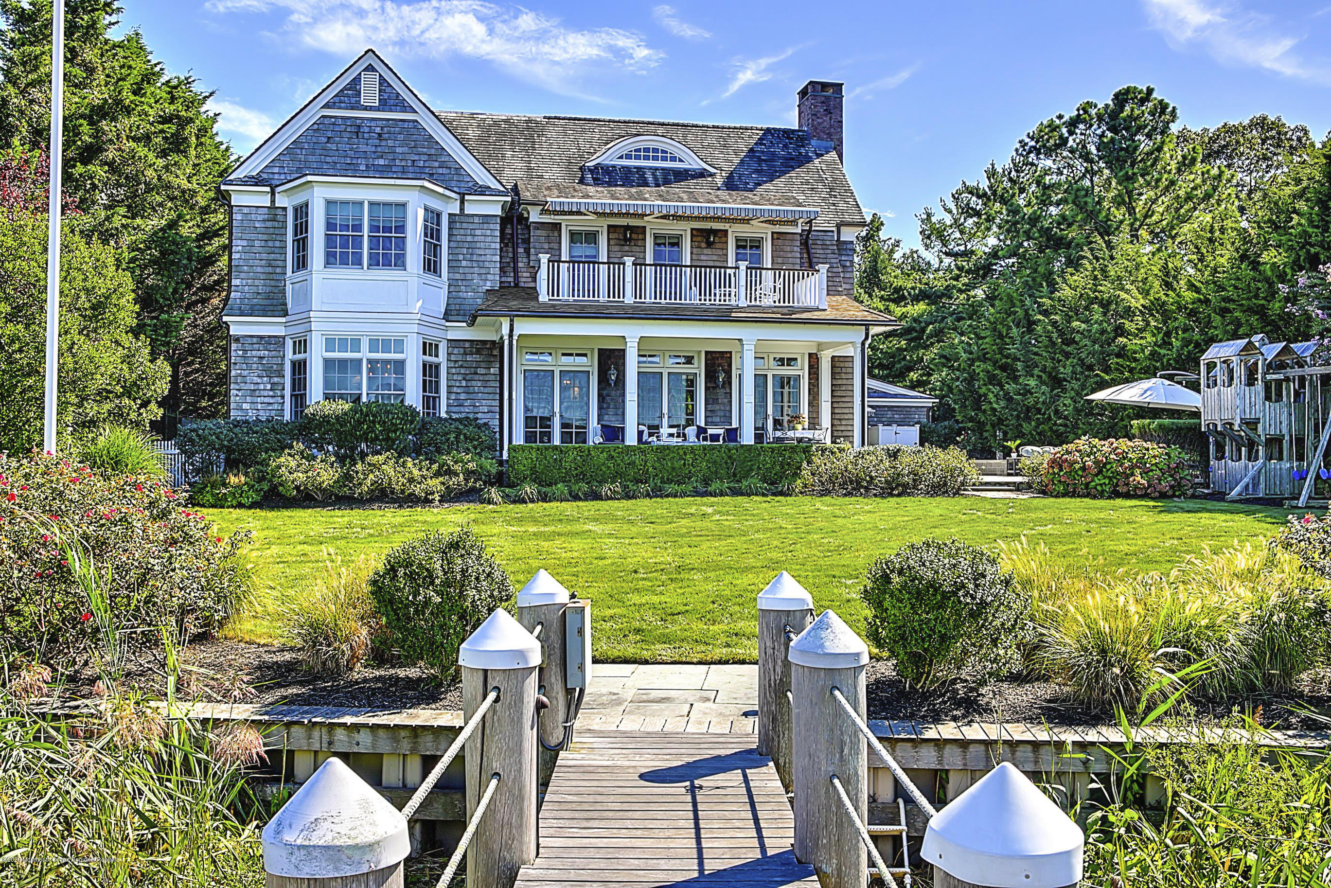 62 River Road Rumson, NJ 07760 - Photo 11 of 54 a front view of a house with swimming pool having outdoor seating