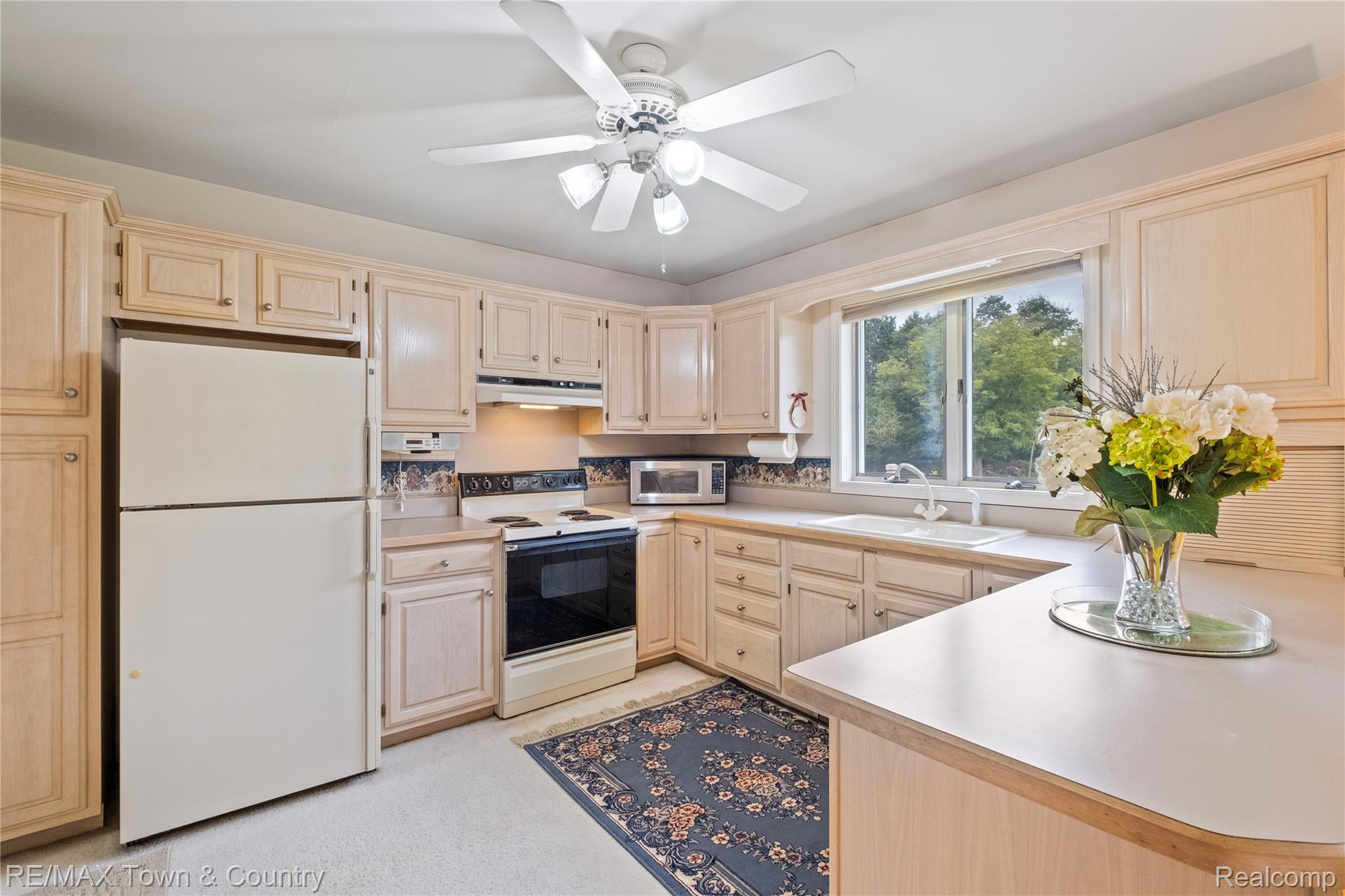 5464 North Seymour Road Flushing, MI 48433 - Photo 24 of 45 Recessed ceiling fan with integrated lighting, extensive light-toned cabinetry, light countertops, double basin sink, and a bay window