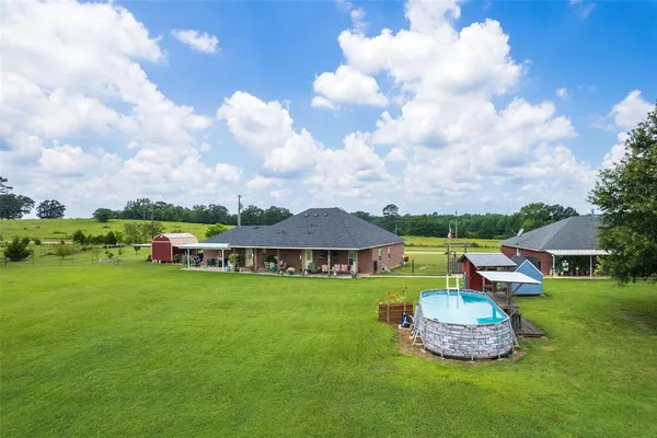 a view of a white house with a yard and sitting area