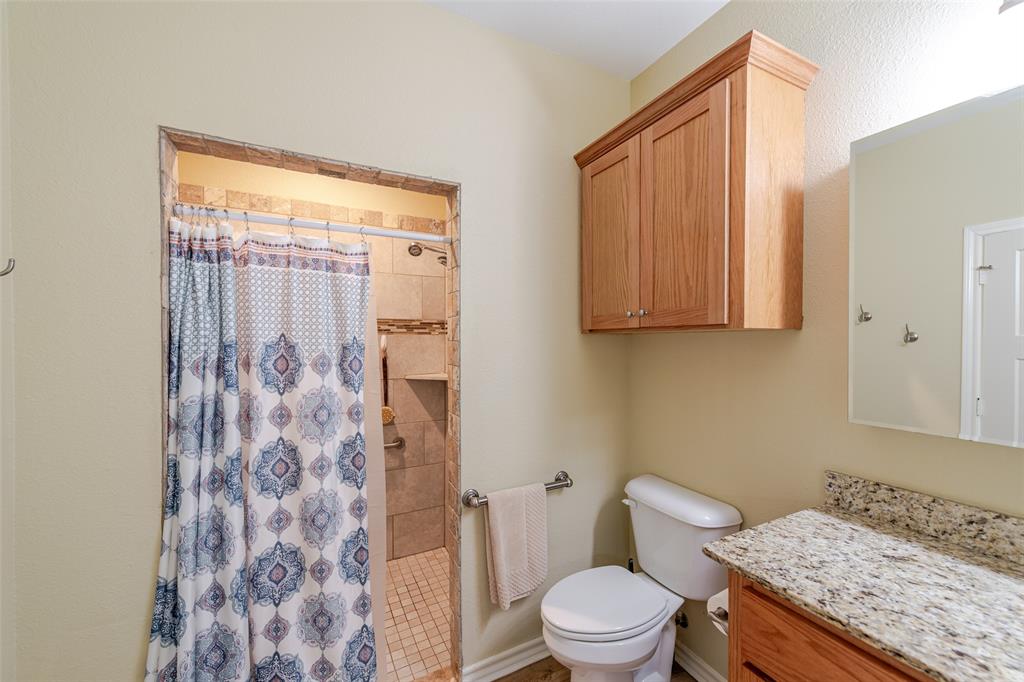 6888 Fm 2888 Naples, TX 75568 - Photo 30 of 40 a bathroom with a granite countertop sink toilet and shower