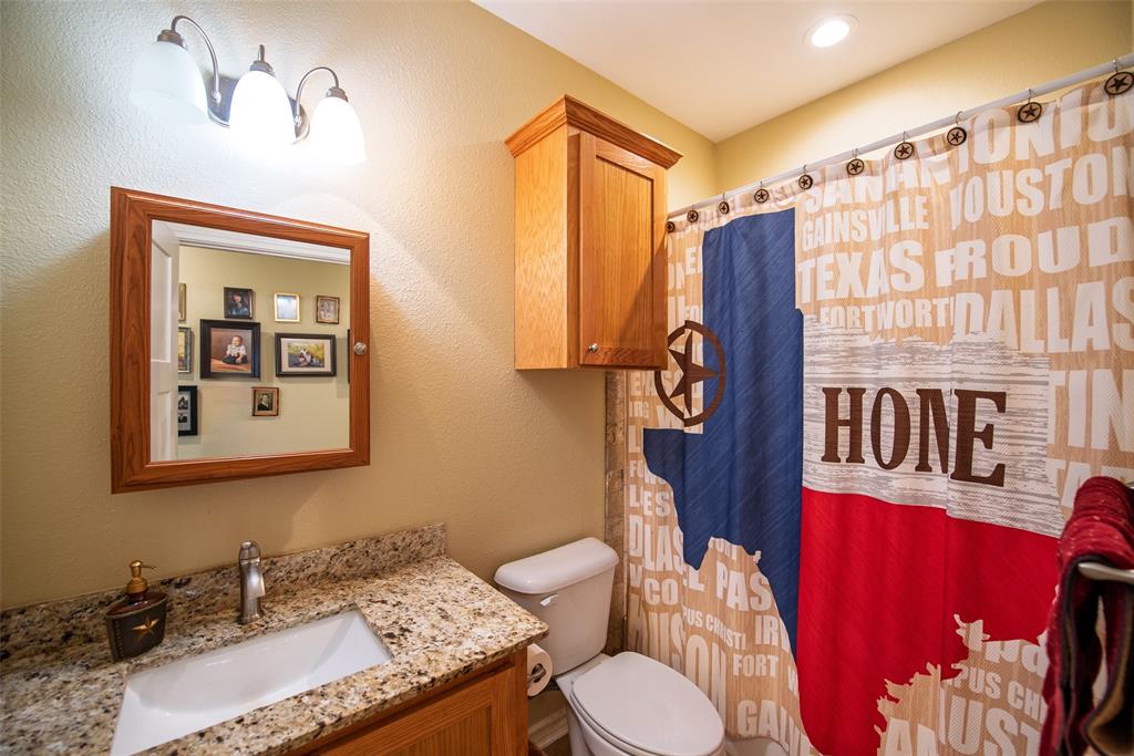 6888 Fm 2888 Naples, TX 75568 - Photo 32 of 40 a bathroom with a granite countertop sink a mirror and a shower