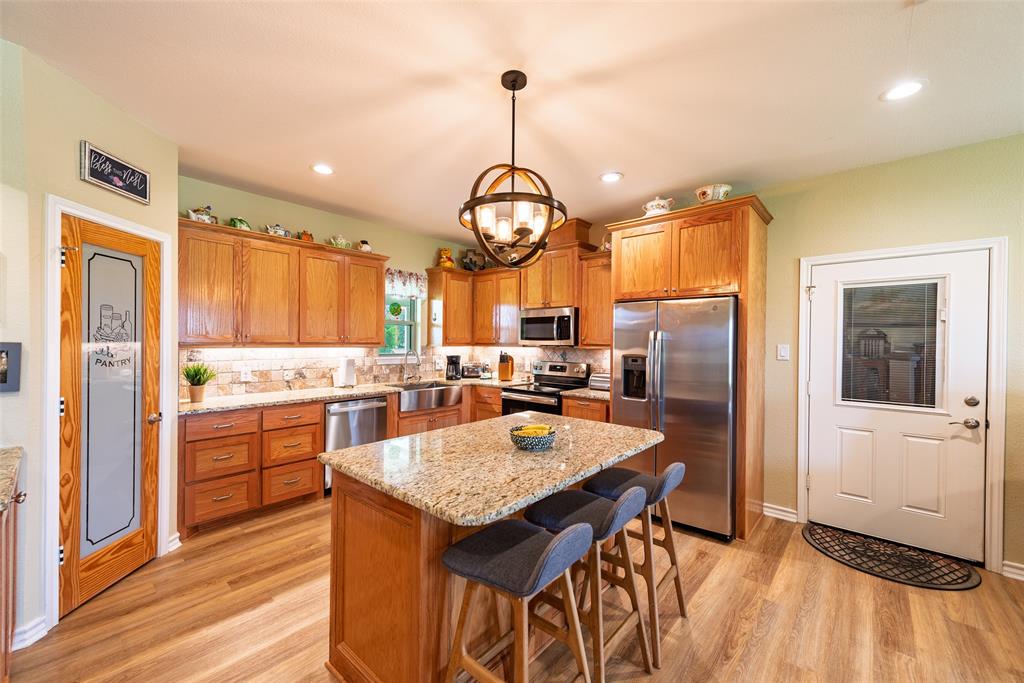 6888 Fm 2888 Naples, TX 75568 - Photo 33 of 40 a large kitchen with granite countertop a stove and a refrigerator