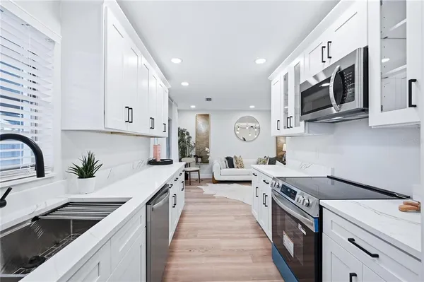 a kitchen with stainless steel appliances granite countertop a sink and a stove
