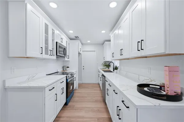 a kitchen with stainless steel appliances granite countertop a sink stove and cabinets