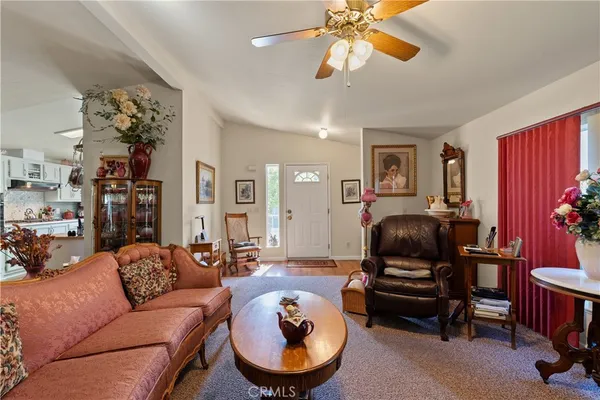 a living room with furniture a ceiling fan and a window