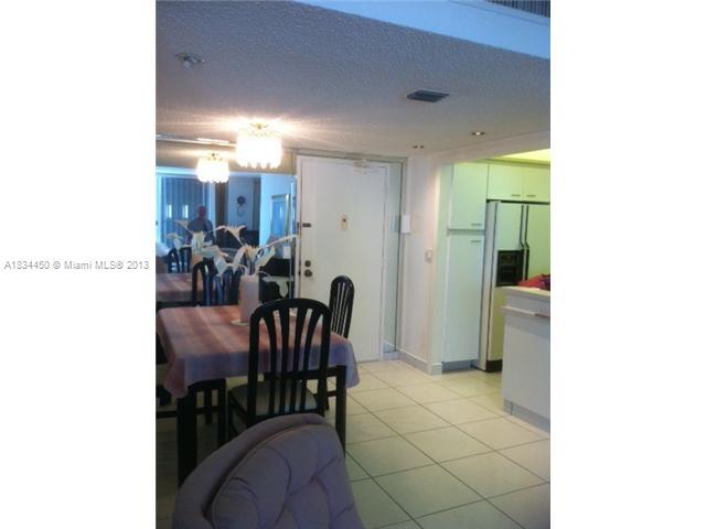 9273 Collins Avenue, Unit 503 Surfside, FL 33154 - Photo 9 of 14 a view of a dining room with furniture and a chandelier
