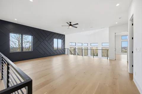 a view of an empty room with a window and wooden floor