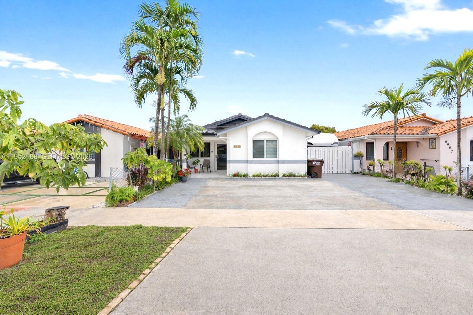 6919 West 29th Way Hialeah, FL 33018 - Photo 1 of 23 a front view of a house with a yard and garage