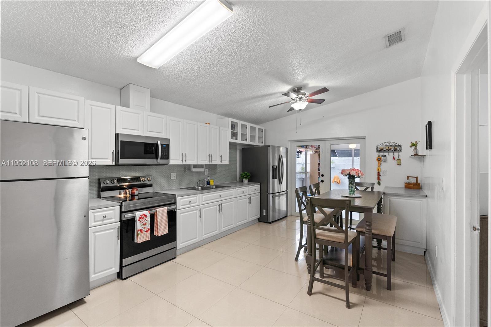 6919 West 29th Way Hialeah, FL 33018 - Photo 5 of 23 a kitchen with stainless steel appliances granite countertop a stove a sink dishwasher a refrigerator with a dining table and chairs