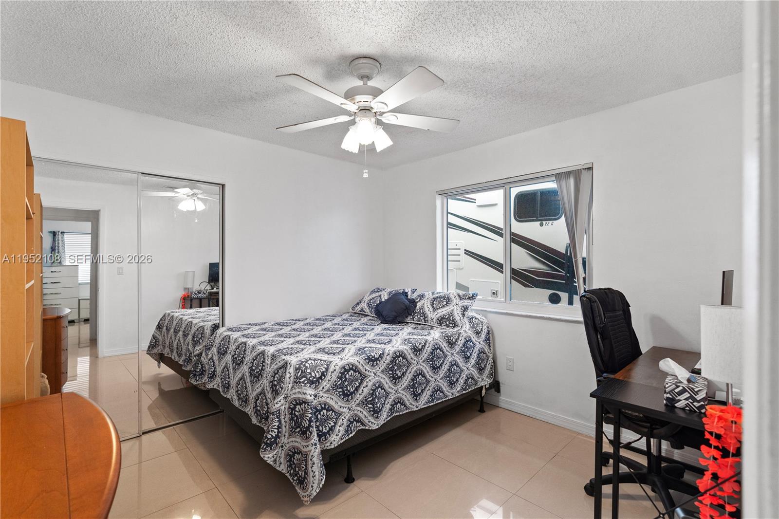 6919 West 29th Way Hialeah, FL 33018 - Photo 8 of 23 a bedroom with a bed and a chandelier