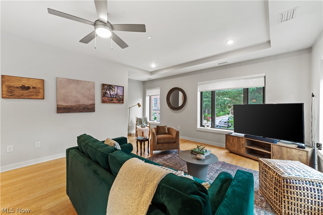 2044 Random Road, Unit 101 Cleveland, OH 44106 - Photo 9 of 44 Living room with light hardwood / wood-style flooring, ceiling fan, and a tray ceiling