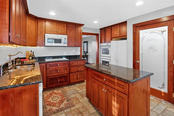 a kitchen with stainless steel appliances granite countertop a refrigerator and a stove top oven