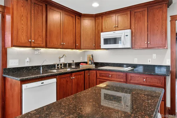 a kitchen with stainless steel appliances granite countertop a sink stove and microwave