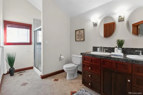 a bathroom with a toilet a sink and mirror
