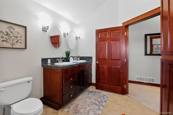 a bathroom with a toilet a sink and mirror