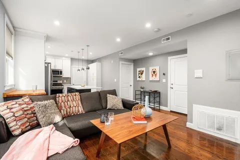 a living room with furniture and a wooden floor