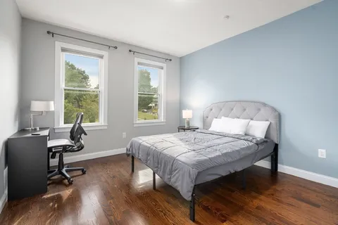 a bedroom with a bed a table and a window