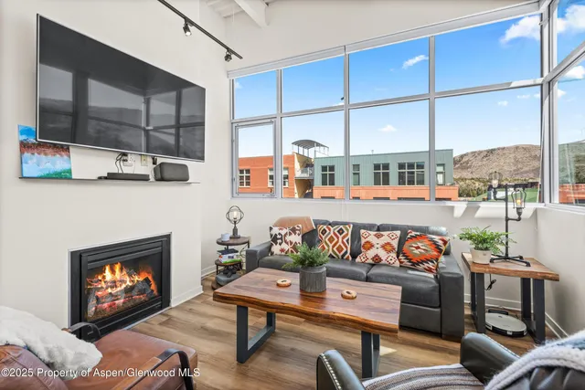 a outdoor living room with furniture a fireplace and a flat screen tv