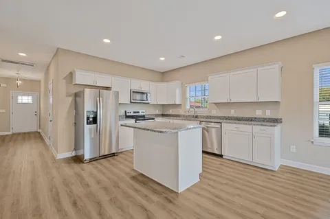 a kitchen with white cabinets and stainless steel appliances