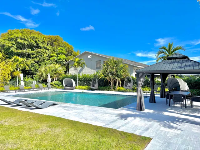 a view of a swimming pool with a table and chairs under an umbrella
