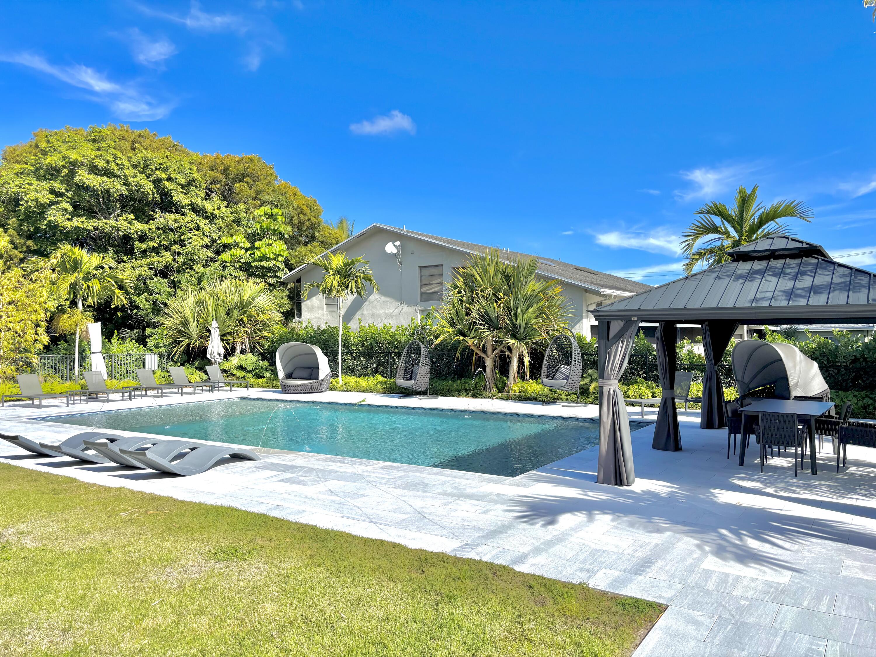 a view of a swimming pool with a table and chairs under an umbrella
