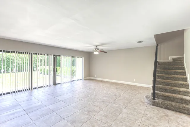 an empty room with windows and stairs