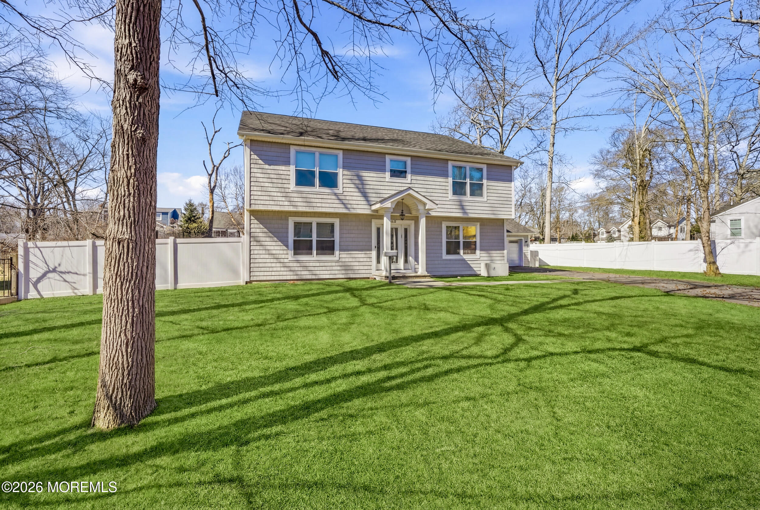 232 Woodcrest Road Oakhurst, NJ 07755 - Photo 12 of 49 a front view of a house with a yard table and chairs