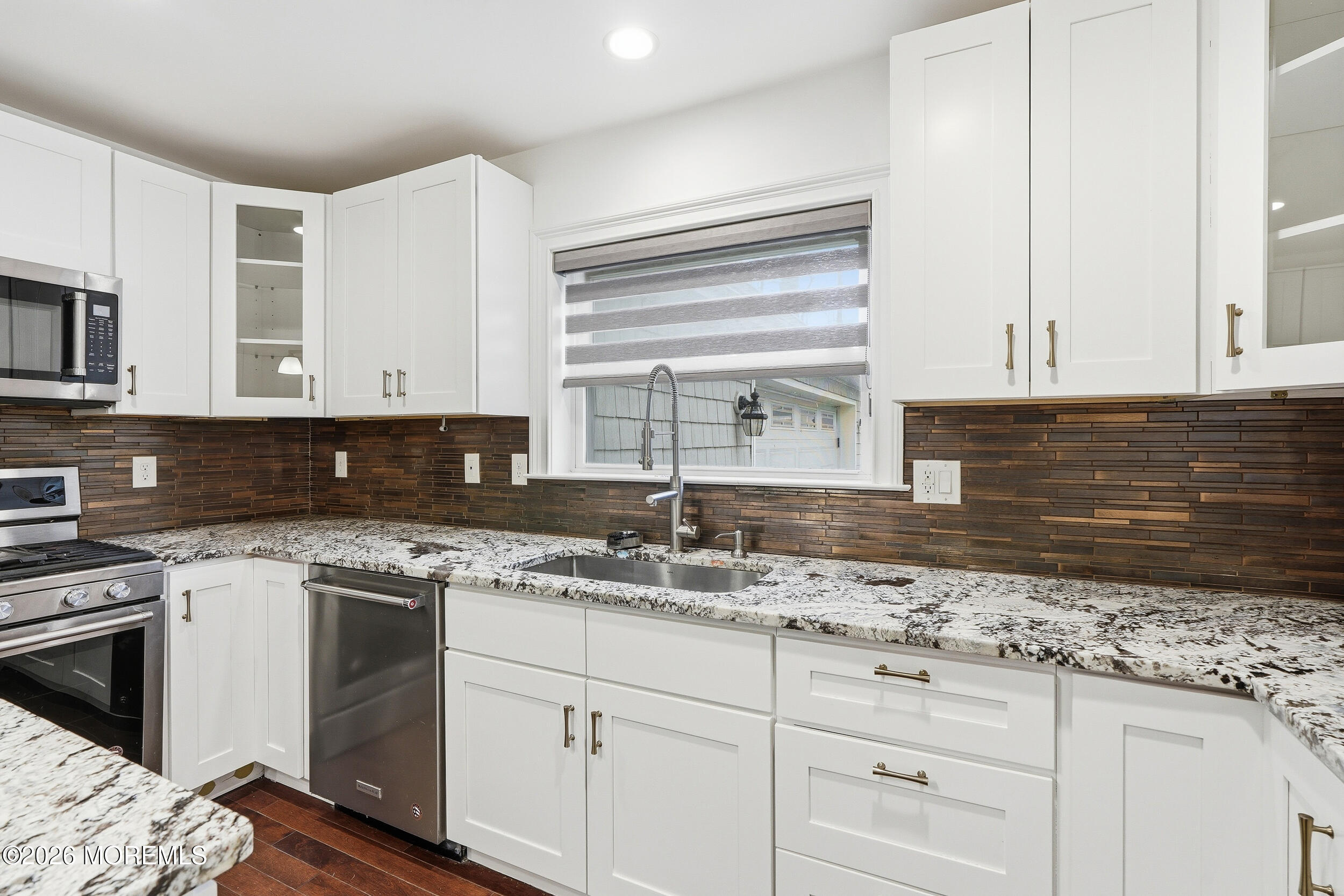 232 Woodcrest Road Oakhurst, NJ 07755 - Photo 15 of 49 a kitchen with granite countertop white cabinets and white appliances
