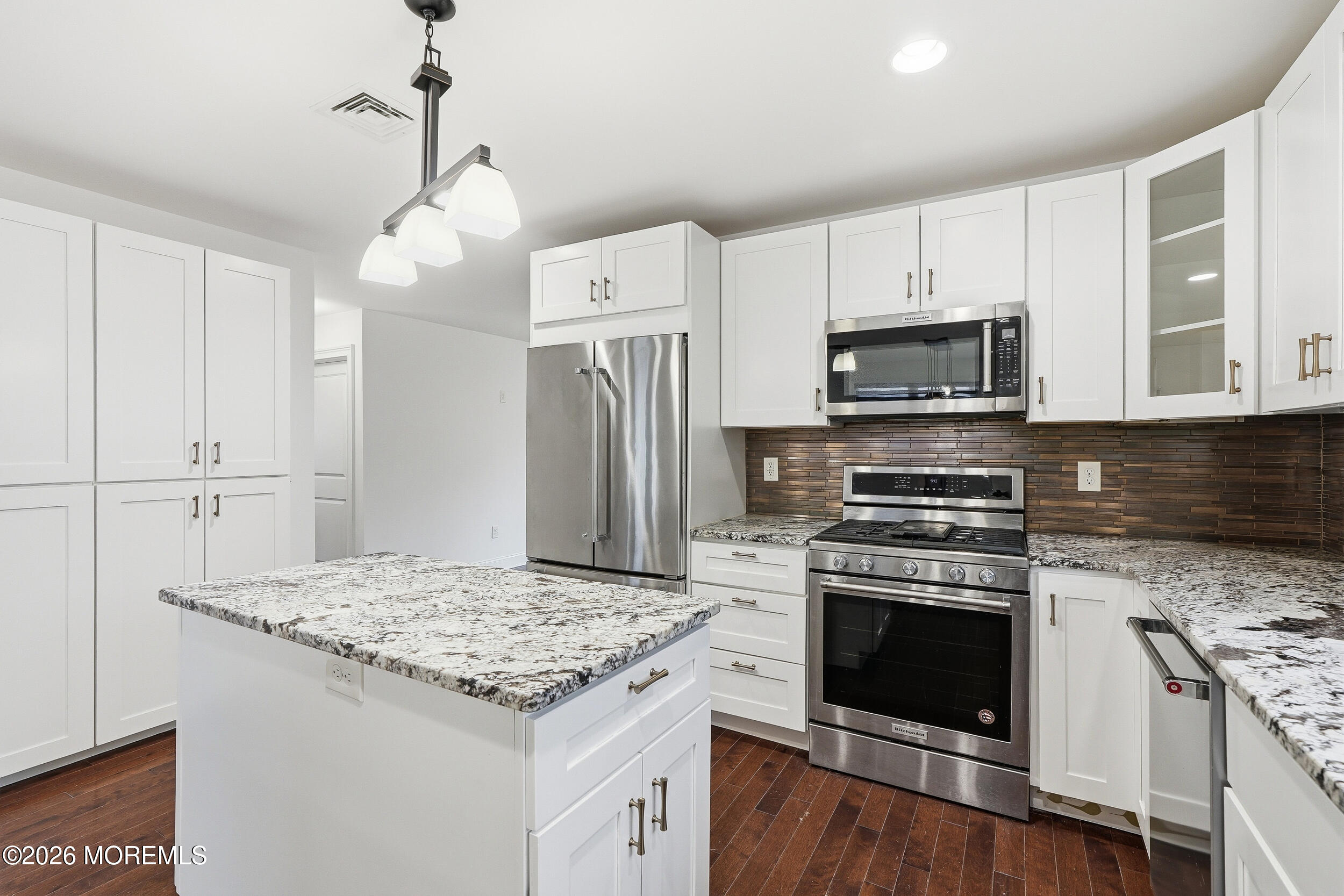 232 Woodcrest Road Oakhurst, NJ 07755 - Photo 16 of 49 a kitchen with kitchen island granite countertop a stove a sink and a refrigerator