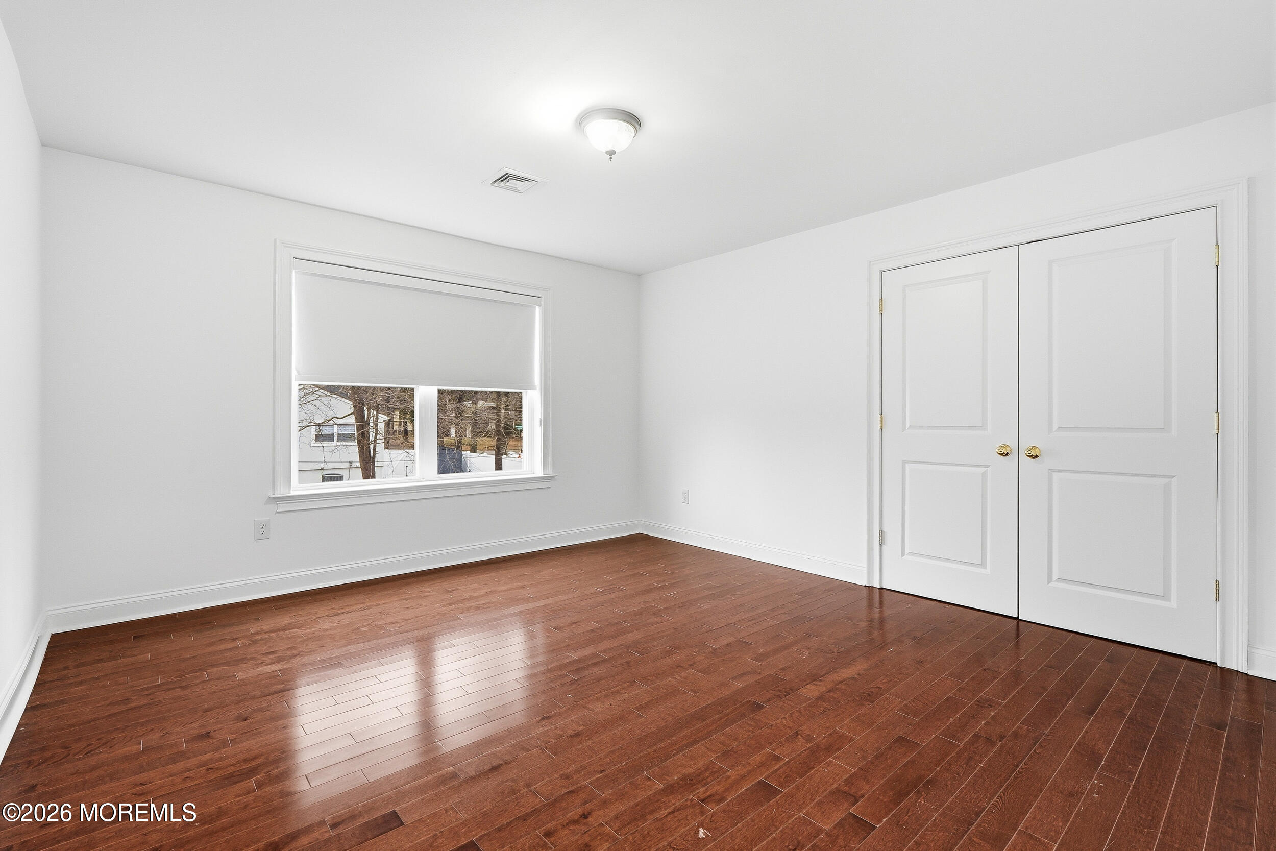 232 Woodcrest Road Oakhurst, NJ 07755 - Photo 26 of 49 a view of an empty room with wooden floor and a window