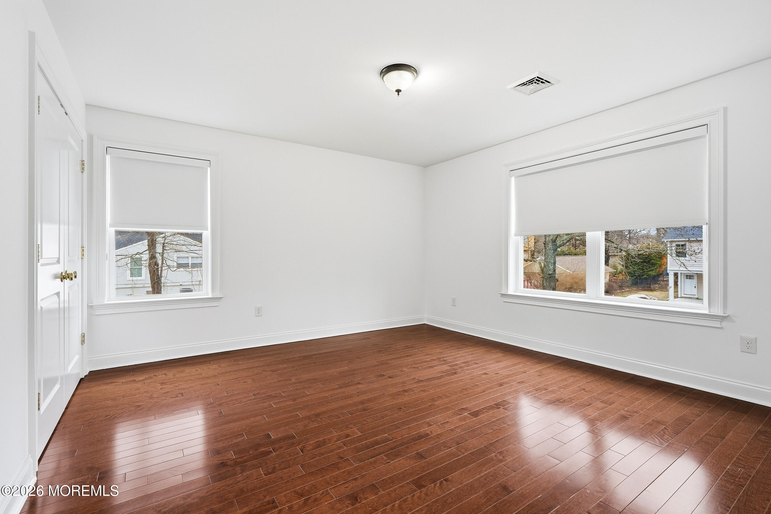 232 Woodcrest Road Oakhurst, NJ 07755 - Photo 28 of 49 a view of an empty room with wooden floor and a window
