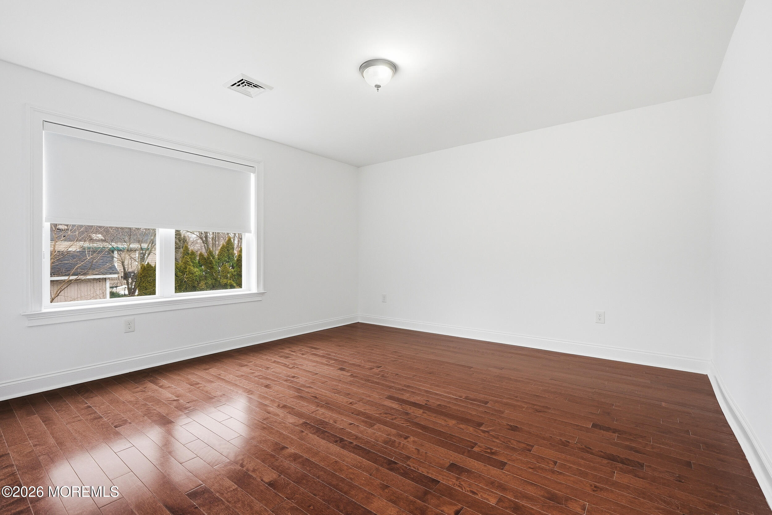 232 Woodcrest Road Oakhurst, NJ 07755 - Photo 29 of 49 a view of an empty room with wooden floor and a window
