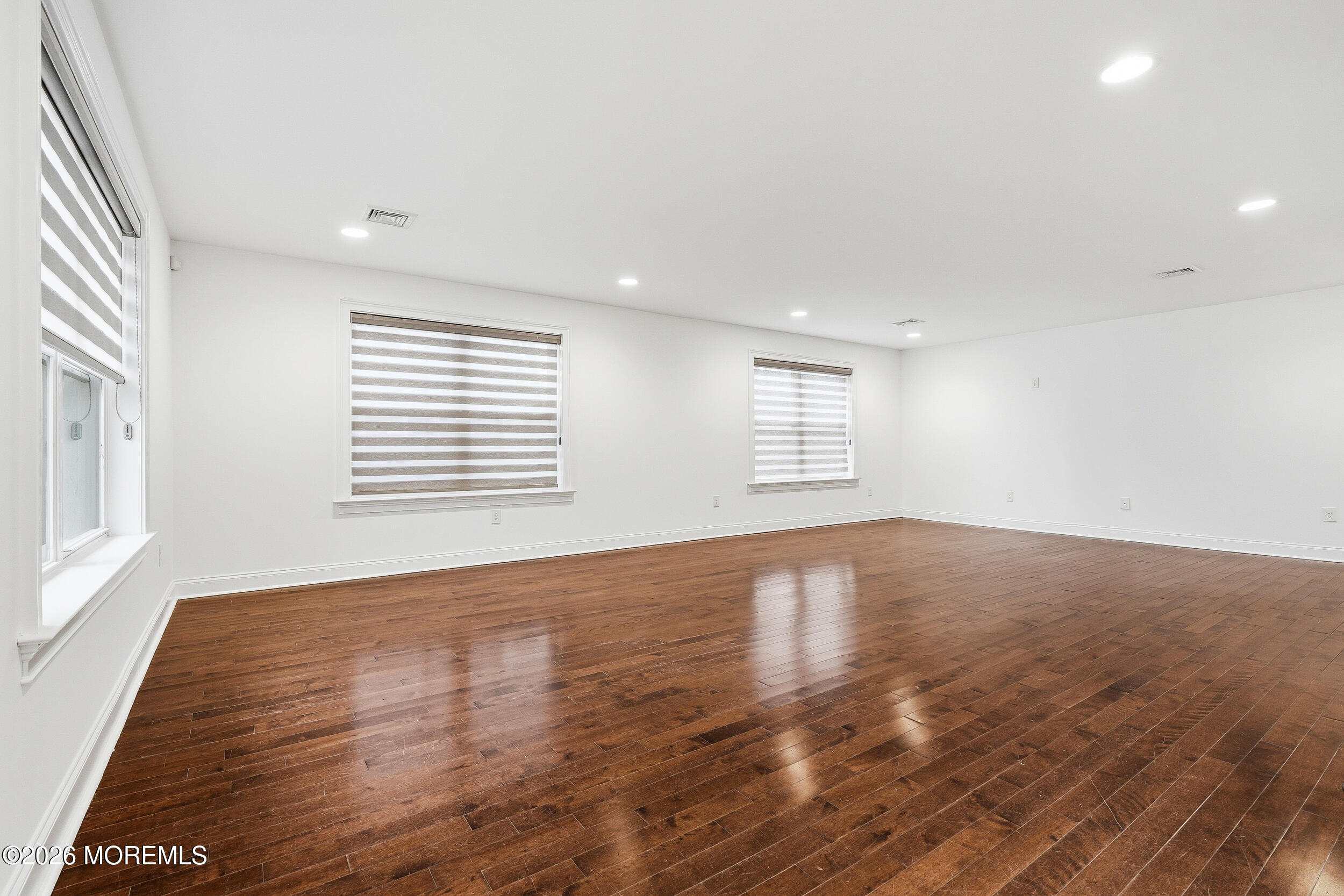 232 Woodcrest Road Oakhurst, NJ 07755 - Photo 9 of 49 an empty room with wooden floor and windows