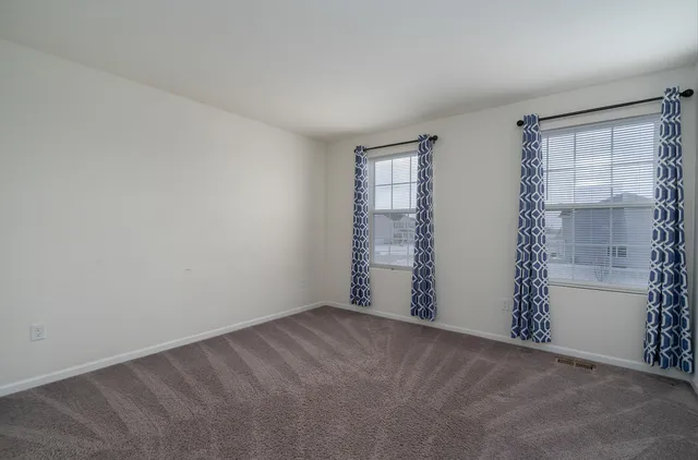 an empty room with windows and closet