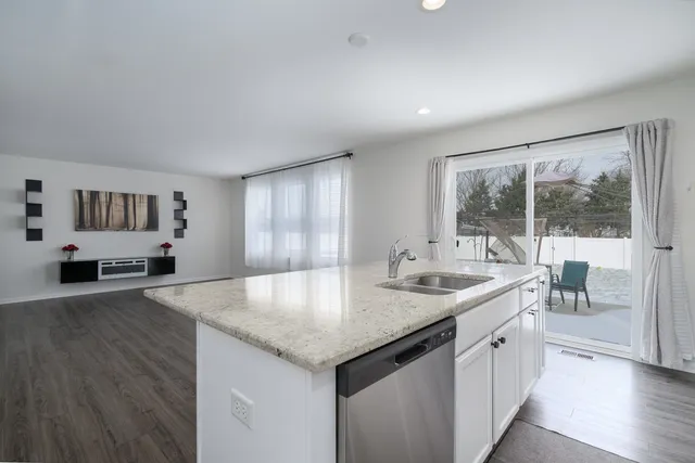 a kitchen with granite countertop a sink and a stove with wooden floor