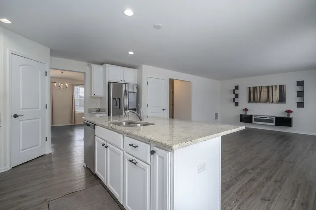 a kitchen with stainless steel appliances granite countertop a lot of counter space and wooden floors