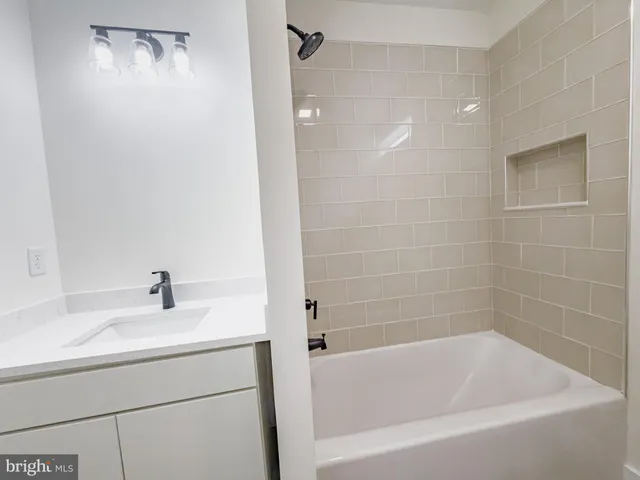 a white bath tub sitting next to a white sink