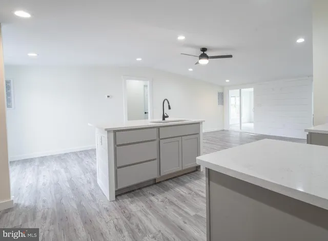 a kitchen with a sink a chandelier and wooden floor