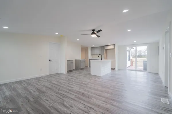 a view of empty room with wooden floor and windows